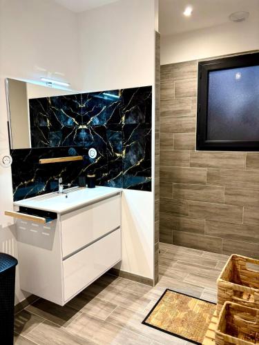 a bathroom with a sink and a tv on the wall at ღ L'escapade romantique ღ de la Vill'ona - LOVEROOM -Ardèche in Grospierres