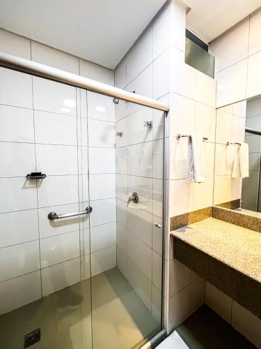 a bathroom with a shower and a sink at Liguori Hotel in Trindade