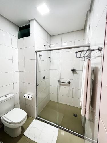 a bathroom with a shower and a toilet at Liguori Hotel in Trindade