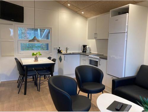 a living room with a table and chairs and a kitchen at Ribe Camping in Ribe