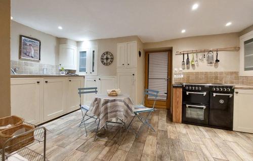 une cuisine avec une table et des chaises dans une pièce dans l'établissement Ancien Chais, aire de loisirs avec piscine, à Marigny