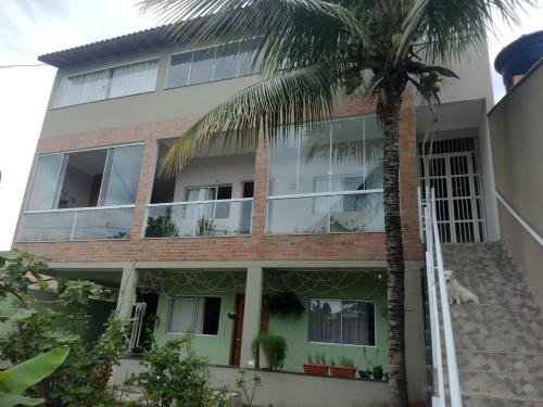 un edificio con una palma di fronte di Casa para temporada Balneário de Carapebus a Serra
