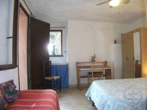 une chambre avec un lit, un bureau et une table dans l'établissement Villa Pierre Vergerie, à Cargèse