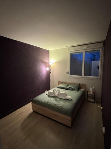 une chambre avec un lit avec deux serviettes dessus dans l'établissement Appartement Cosy, à Montceau-les-Mines