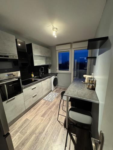 une cuisine avec un comptoir et une table à l'intérieur dans l'établissement Appartement Cosy, à Montceau-les-Mines