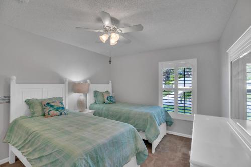 a bedroom with two beds and a ceiling fan at Fishtail Getaway in Sebastian