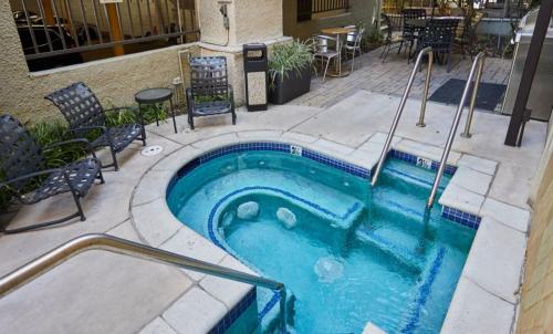 a small swimming pool with chairs and a table at Beverly Hills Chic 2 bed 2bath with Patio and Parking 309 in Los Angeles