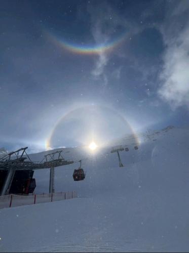a ski lift in the snow with a rainbow in the sky at Gästehaus Alpenblick in Mutters