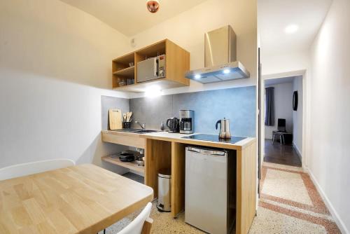 une petite cuisine avec un comptoir en bois et une table dans l'établissement Apartment Place Stanislas 3, à Nancy
