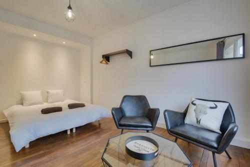 une chambre avec un lit, une chaise et une table dans l'établissement Apartment Place Stanislas 3, à Nancy