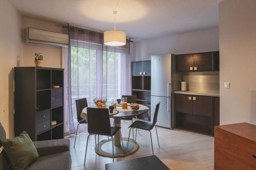 une cuisine et une salle à manger avec une table et des chaises dans l'établissement Le Rivieira garage et terrasse, au bord du Lez, à Montpellier
