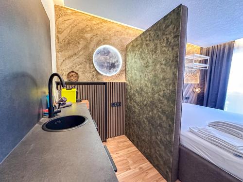 a bathroom with a sink and a bed in a room at Luna Studios Zillertal in Hippach
