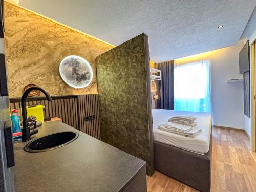 a kitchen with a sink and a bed in a room at Luna Studios Zillertal in Hippach