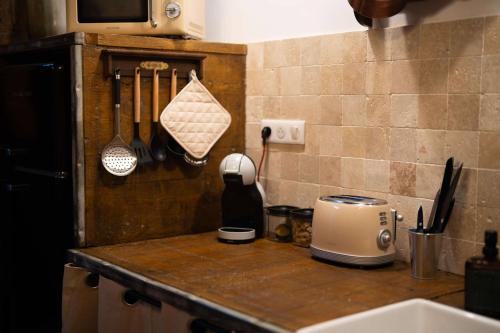 a kitchen counter with utensils on a counter top at Les sorciers de Lauzerte immersion magique in Lauzerte