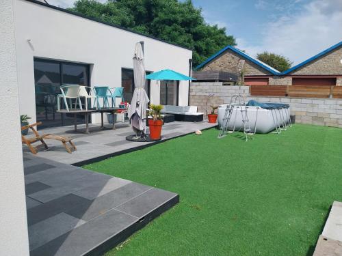 une cour avec une pelouse verdoyante dans l'établissement Maison entière, à Guidel