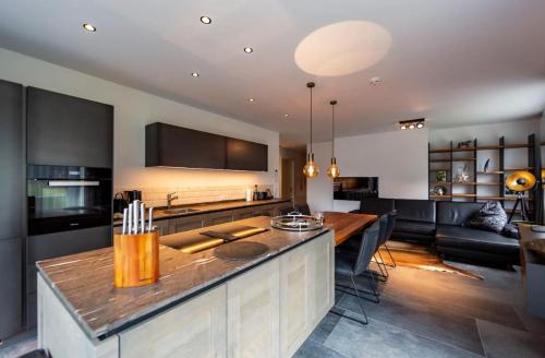 a kitchen and living room with a table and a couch at Hollywood Dream Penthouse & Apartments mit privater Sauna nahe Ischgl in Kappl