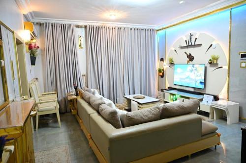 a living room with a couch and a television at T-point Apartments in Lekki