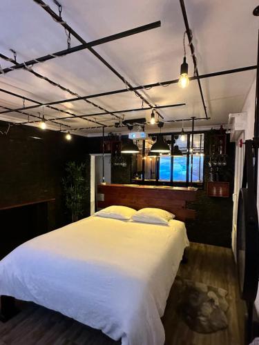 une chambre avec un grand lit avec des draps blancs dans l'établissement Love Room, Jacuzzi & Cinema House, à Mérignac