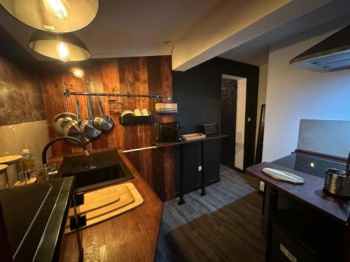 - une cuisine avec des murs en bois et un comptoir dans l'établissement Love Room, Jacuzzi & Cinema House, à Mérignac