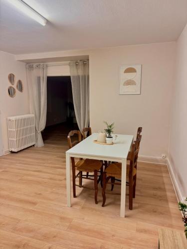 une salle à manger avec une table et des chaises blanches dans l'établissement 1-Cinema apartment 10 min from Futuroscope, à Saint-Cyr