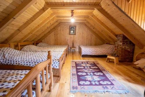 Zimmer im Dachgeschoss mit 2 Betten und einem Teppich in der Unterkunft Holiday cottages with pool in Plav