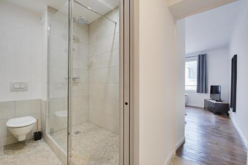 een badkamer met toilet en glazen douche bij Appartement Place Stanislas 4eme in Nancy