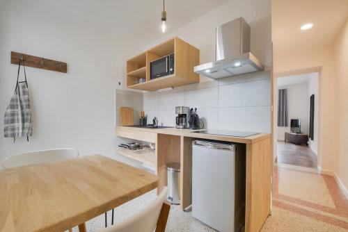 - une cuisine avec une table en bois et un comptoir dans l'établissement Appartement Place Stanislas 4eme, à Nancy