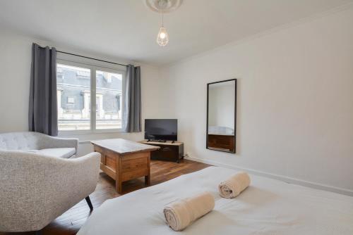 een woonkamer met 2 bedden en een televisie bij Appartement Place Stanislas 4eme in Nancy