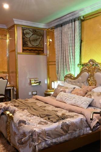 a bedroom with a large bed with a gold headboard at T-point Apartments in Lekki