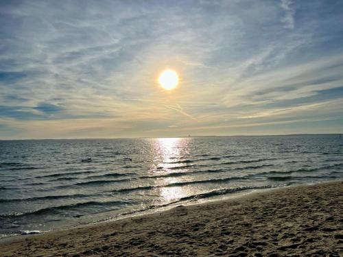 a sunset on the beach with the sun in the sky at Ferienwohnung Ostseefeuer in Eutin