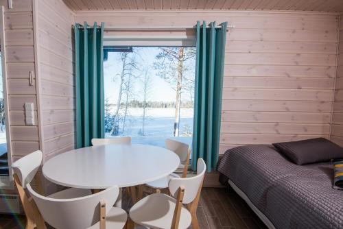 una camera con tavolo e sedie, un letto e una finestra di Kajaani Cottages a Kajaani