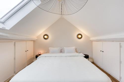 a bedroom with a large white bed with a ceiling at LE COCON- Confort & Cosy à Proximité de Disneyland in Chessy