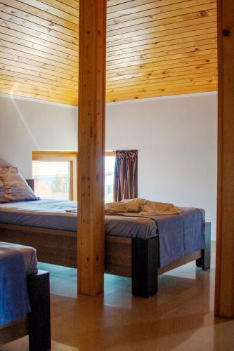 two beds in a room with wooden ceilings at Sani Holiday Village in Sozopol