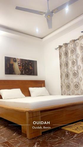 a bedroom with a large wooden bed in a room at Residence The Champion 2 in Ouidah