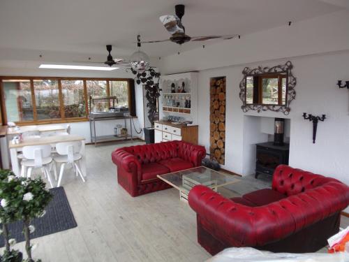 a living room with two red couches and a table at Barton Gate Farm B&B in Bude