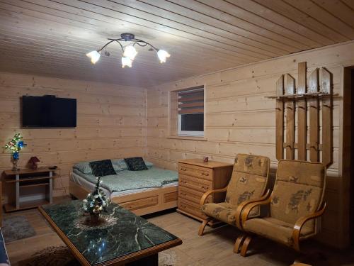 a bedroom with a bed and a desk in a room at Domek nad Stawem in Istebna