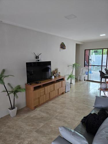 a living room with a couch and a television at Casa de campo e praia in Conde