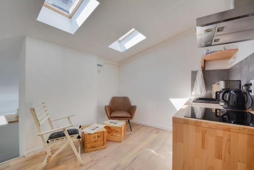 - une cuisine avec un comptoir et une chaise dans une pièce dans l'établissement Appartement Place Stanislas 5eme, à Nancy