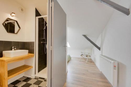 een badkamer met een wastafel en een spiegel bij Appartement Place Stanislas 5eme in Nancy