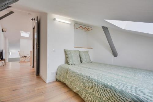 een slaapkamer met een bed in een witte kamer bij Appartement Place Stanislas 5eme in Nancy