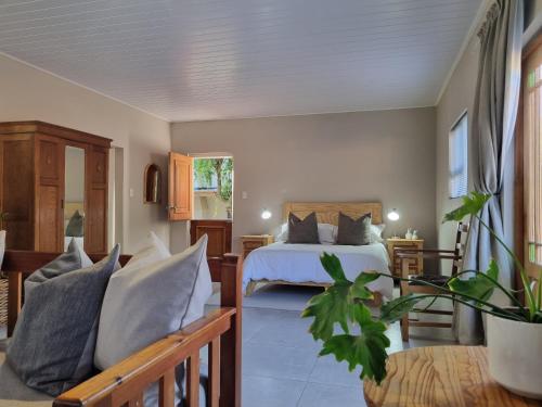 a bedroom with a bed and a couch in a room at Lambertshoek Farm Stay in Graafwater
