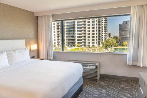 a hotel room with a bed and a large window at Orange County Hotel in Santa Ana