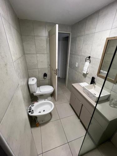 a white bathroom with a toilet and a sink at Terra Bella Hidromasajes in San Antonio de Arredondo