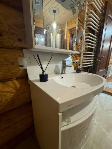 a bathroom with a white sink and a mirror at Садиба Сикитура in Verkhneye Vodyanoye