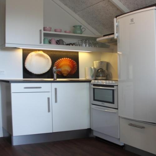 a kitchen with white cabinets and a white refrigerator at Ribe Camping in Ribe
