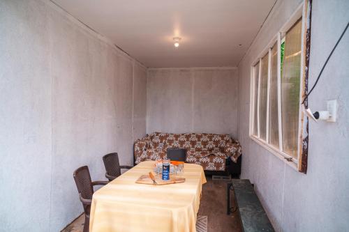 a table and chairs in a room with a couch at Cabañas El Bosque in Maitencillo