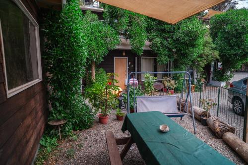 a garden with a table and a chair and a house at Cabañas El Bosque in Maitencillo