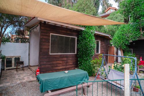 a small house with a table and a canopy at Cabañas El Bosque in Maitencillo