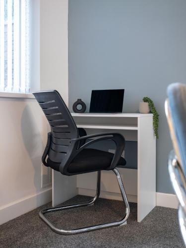 a black chair sitting at a desk with a computer at Comfortable 3BR Home, Driveway with Free Parking, Contractors-Family Welcome in Parkside