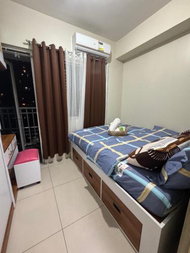 a bedroom with a bed with a blue and yellow blanket at Condo in Pasay in Manila
